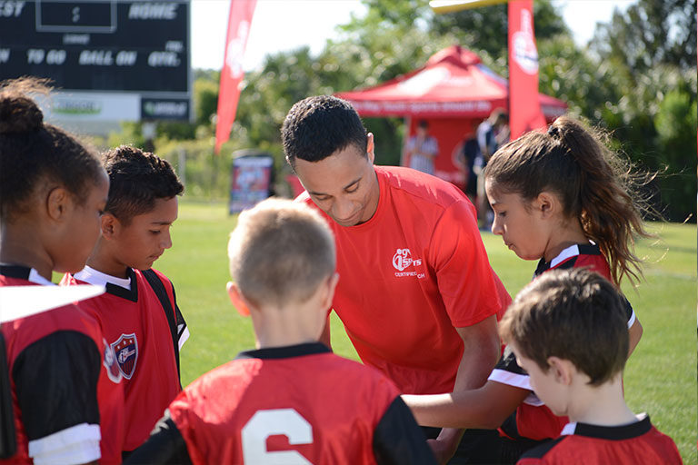 About i9 Sports Soccer coach reviews a play in the team huddle